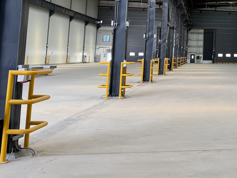 The column line inside the workshop, with yellow impact guards along the bays.